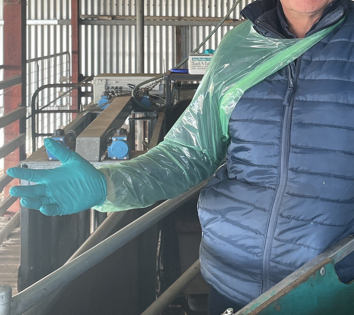 Nitrile hand glove over shoulder length plastic glove with neck loop.